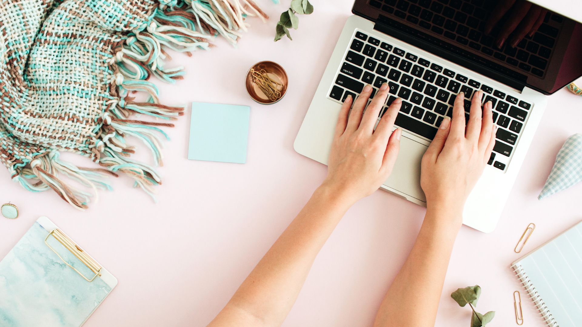 Woman typing on keyboard of laptop